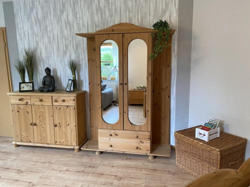 a wooden cabinet with a mirror in a room at One-bedroom apartment in Urbar
