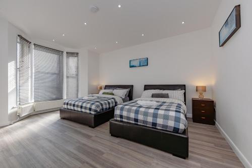 a bedroom with two beds and a window at Triple B Aparto in Clacton-on-Sea