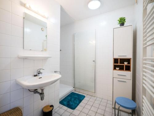 a white bathroom with a sink and a shower at Holiday apartment in Buren with swimming pool in Buren
