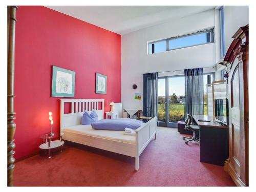 a bedroom with a red wall with a bed and a desk at Holiday apartment in Munich with Wi-Fi in Munich