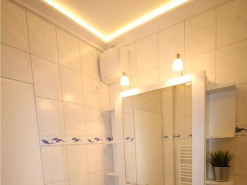 un baño con espejo y lavabo en Dike crown in Haus Grimmershörn, en Cuxhaven