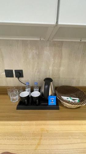 a kitchen counter with a tea kettle and two cups at غرفة وصالة فندقية في حي الورود in Al Kharj