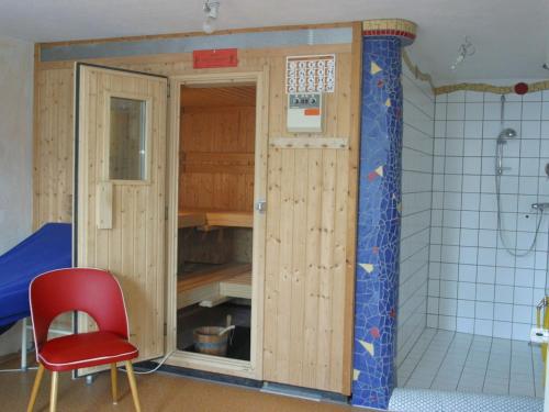 a room with a closet in a bathroom with a red chair at Holiday home with 2 bedrooms in Schwollen
