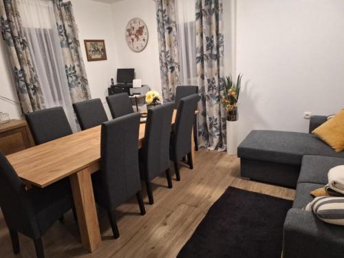 a dining room with a wooden table and chairs at Apartment and Room Mare Vrlika - Double Bedroom with Terrace and External Kitchenette in Maovice