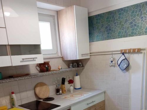 a kitchen with white cabinets and a counter top at Apartments Julia - Studio Apartment Julia 1 in Martinšćica