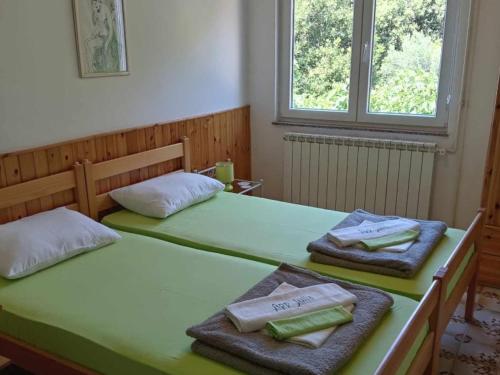 two beds in a room with towels on them at Apartments Julia - Studio Apartment Julia 1 in Martinšćica