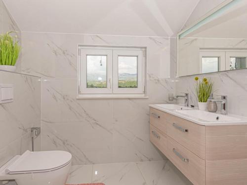 a white bathroom with a toilet and a sink at Villa Maria with Outdoor Pool - Five Bedroom Villa with Outdoor Pool in Otavice