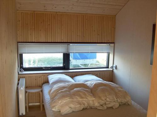 een bed in een kleine kamer met een raam bij Holiday home in Thisted with swimming pool in Nørre Vorupør