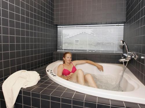 een vrouw zit in een bad bij Holiday home in Thisted with swimming pool in Nørre Vorupør