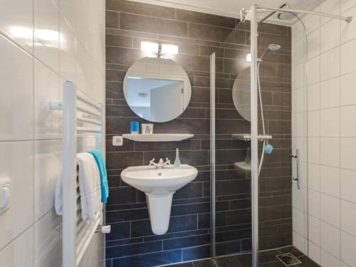 a bathroom with a sink and a glass shower at Holiday home in Nes with swimming pool in Nes