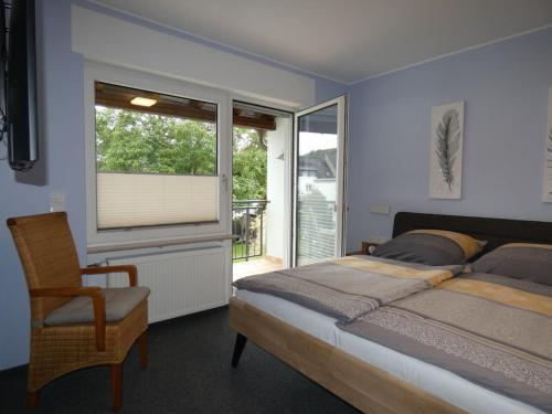 a bedroom with a bed and a chair and a window at Holiday home with 3 bedrooms in Treis-Karden