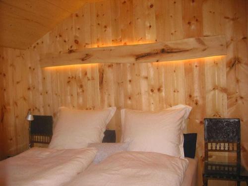 a bedroom with two beds in a wooden wall at 1-bedroom holiday home in Sachrang