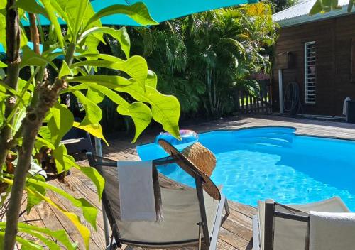 a table and chairs next to a swimming pool at Hébergement Yucca - Saint-François in Saint-François