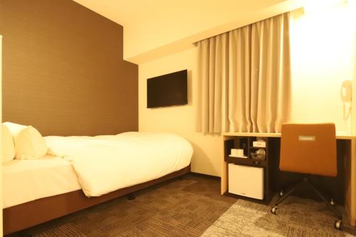 a hotel room with a bed and a television at AB Hotel echizentakefu in Echizen-shi