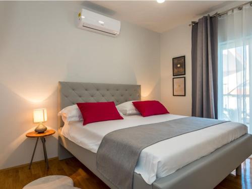 a bedroom with a large bed with two red pillows at Villa Branka - Villa Tomi Drni - Siveri in Siverić
