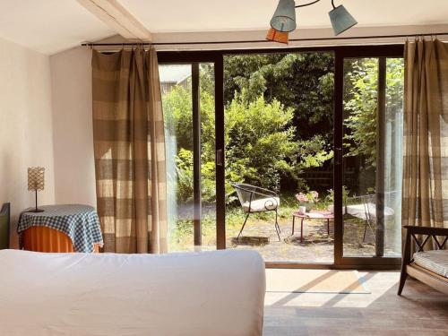 een slaapkamer met een bed en een groot glazen raam bij Holiday home with 2 bedrooms in Katzenthal