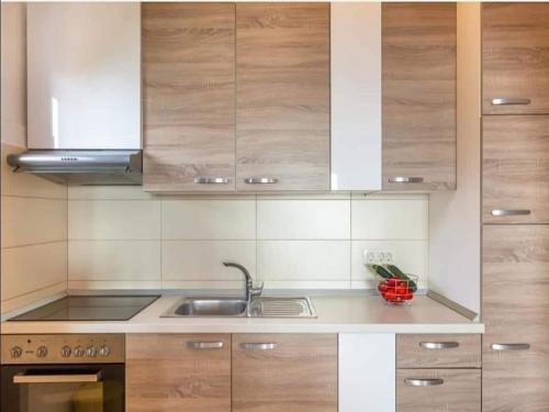 a kitchen with wooden cabinets and a sink at Two Bedroom Apartment With Terrace A4 in Brist
