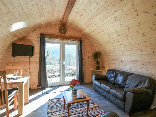 a living room with a leather couch and a table at Creyr Glas Pod -Uk41796 in Hirnant