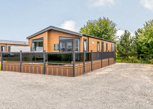 a house on a gravel lot with a fence at Hanworth Country Park in Potter Hanworth