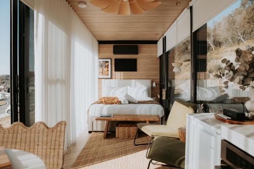 a bedroom with a bed and a living room at The Bambino - By Casa Bicheno in Bicheno