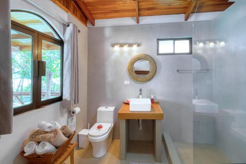 a bathroom with a toilet and a sink and a mirror at Mariposa Monarca in Esterillos