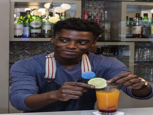 a man sitting at a bar with a drink at Mercure Paris Vaugirard Porte De Versailles in Paris