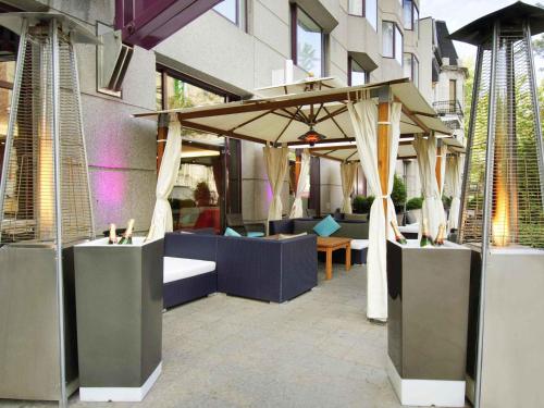 a patio with tables and umbrellas in front of a building at Novotel Montreal Center in Montréal