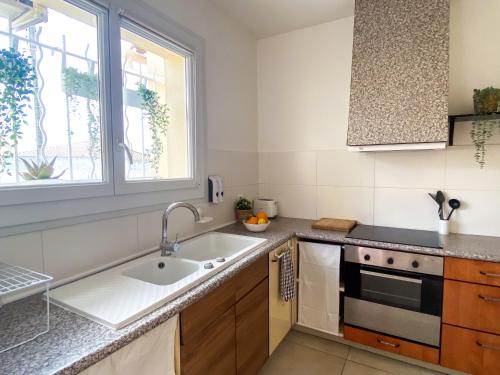 une cuisine avec un évier et une fenêtre dans l'établissement Chambre simple avec terrasse privée - Proche tram et centre - Cuisine et Salle de bain en partage, à Montpellier