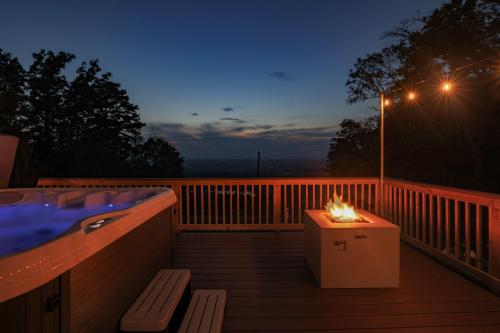 a deck with a hot tub and a table with a candle at Iconic Chalet with Sauna, Hot Tub, Fire Pit, Plunge in Harpers Ferry