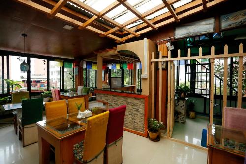 a restaurant with colorful chairs and tables and windows at Shangrila Boutique Hotel in Kathmandu