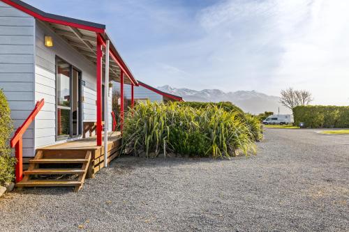 a building with a porch and some plants next to it at Kaikōura TOP 10 Holiday Park in Kaikoura