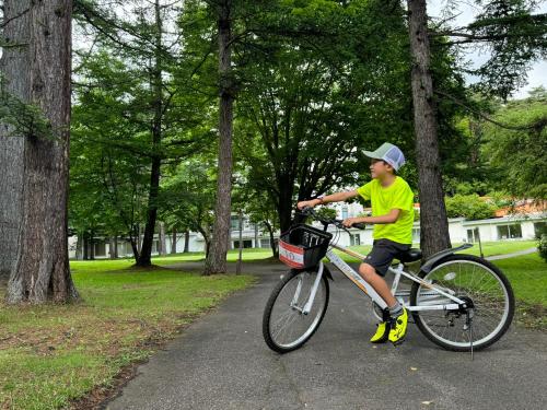 a young boy riding a bike in a park at Kusatsu Onsen Hotel Village in Kusatsu
