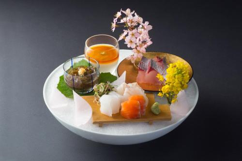 a plate of food on a table with a drink at Yufuin Souan Kosumosu in Yufuin