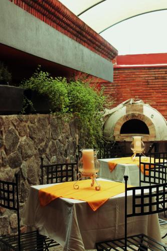 an outdoor table with a pizza oven on a patio at Hotel Art Gallery Casona de los Milagros in Colima