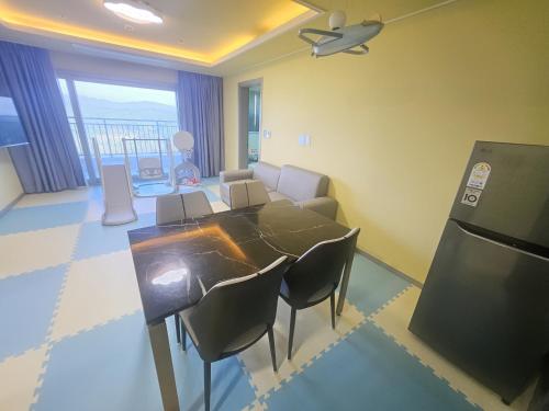 a living room with a table and chairs and a kitchen at 강진 다산베아채 골프앤리조트 호텔형 in Songhak