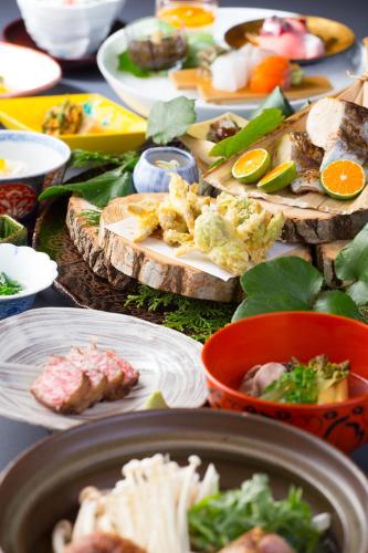 a table with many plates of food on it at Yufuin Souan Kosumosu in Yufuin