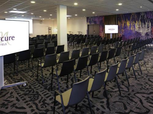 a conference room with chairs and a screen at Mercure Angoulême Hôtel de France in Angoulême