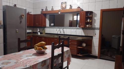 a kitchen with a table with a bowl of fruit on it at COP30 house in Ananindeua