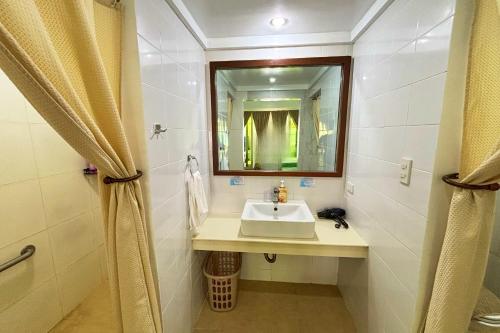 a bathroom with a sink and a mirror at Arkipelago Divers and Beach Resort in Puerto Galera