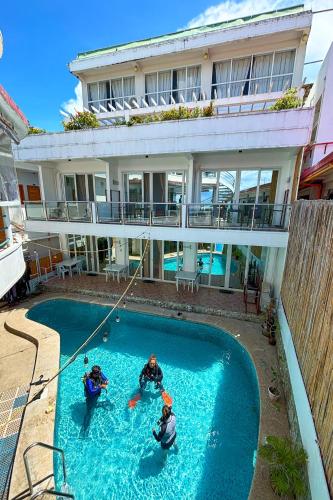 three people playing in a swimming pool in a house at Arkipelago Divers and Beach Resort in Puerto Galera