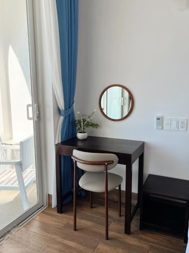 a black table with a chair and a mirror at Babylon Hotel Phu Quy in Îlot du Sud