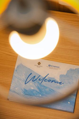 a welcome card sitting on top of a table at Wyndham Hoi An Royal Beachfront Resort & Villas in Hoi An