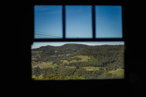 a view of a mountain through a window at Refúgio dos Capitéis in Farroupilha