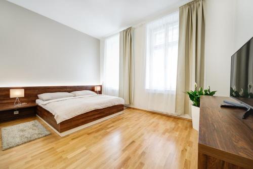 a bedroom with a bed and a large window at Bishop Apartments in Brno