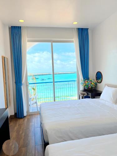 a bedroom with a view of the ocean at Babylon Hotel Phu Quy in Îlot du Sud