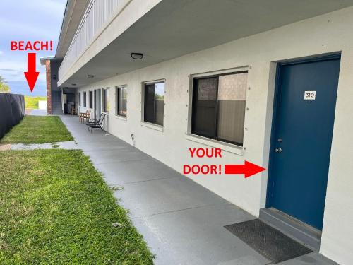 Una puerta en un edificio con un cartel que dice "tu puerta" en Beachside 1-Bedroom Condo in Cocoa Beach, Florida - 125 Feet to Beach!, en Cocoa Beach