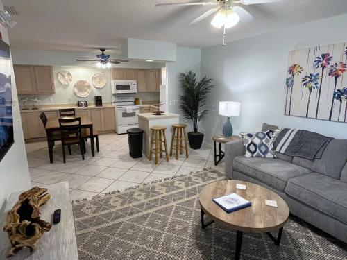 una sala de estar con un sofá y una mesa en Beachside 1-Bedroom Condo in Cocoa Beach, Florida - 125 Feet to Beach!, en Cocoa Beach