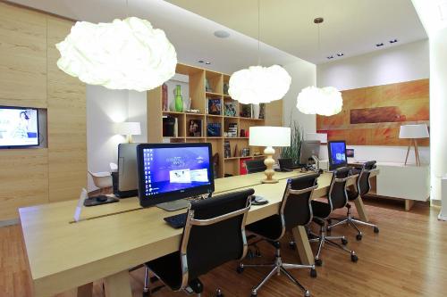 a room with a desk with a computer and chairs at Fiesta Inn Express Puebla Explanada in Puebla