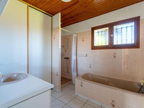 un bagno con vasca, doccia e lavandino di Maison au bord du lac de Biscarrosse - 6 pers - Jardin et parking - Proche pistes cyclables - FR-1-319-511 a Biscarrosse