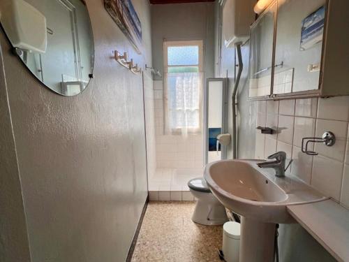 a bathroom with a sink and a toilet and a mirror at Maison calme près plage - 6 pers - Animaux admis - FR-1-540-284 in Notre-Dame-de-Monts